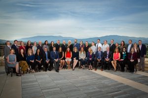 Worden Thane Lawyers pose for group photo on a rooftop, Missoula, Montana skyline and mountain scenery