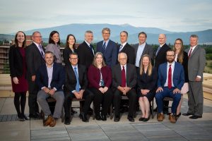 Worden Thane Lawyers pose for group photo on a rooftop, Missoula, Montana skyline and mountain scenery