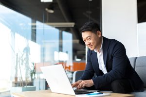 Registered agent in professional attire working on a laptop.