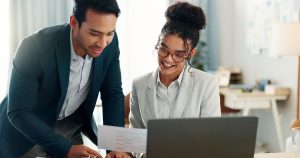 Two intellectual property lawyers sit at a laptop researching trademarks for a client.